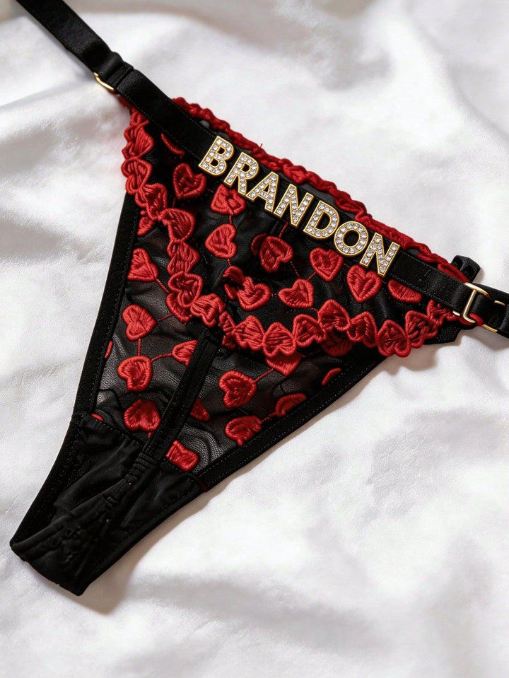 Front flat lay of custom name red heart embroidered mesh thong with gold buckles