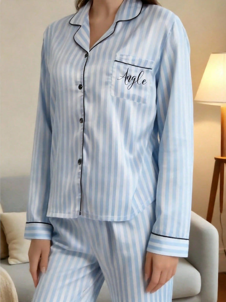 Close-up of personalized custom name embroidered text on pocket of blue striped women's satin pajamas
